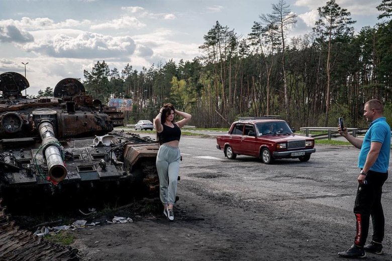 Українки позують на тлі згорілих російських танків 01