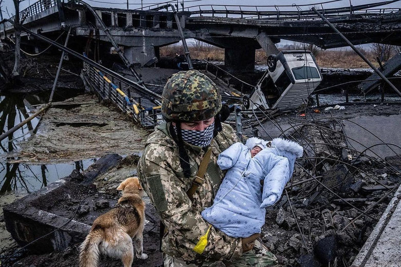 Український воїн переносить немовля через руїни 01